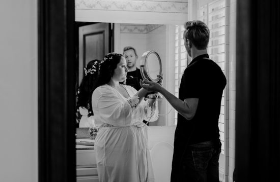 Bride looks at her hair in the mirror