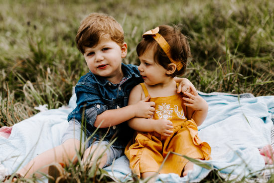 Baby and toddler on a blanket for their family photo session