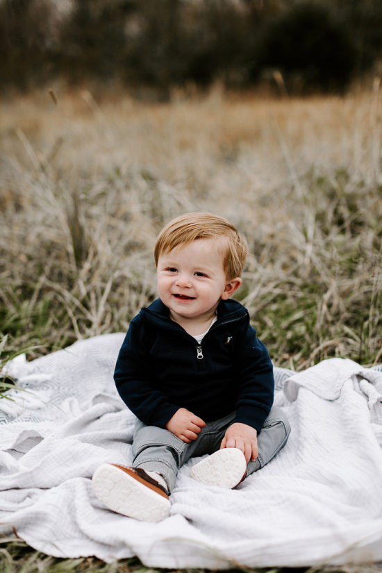 Baby boy sitting in a field