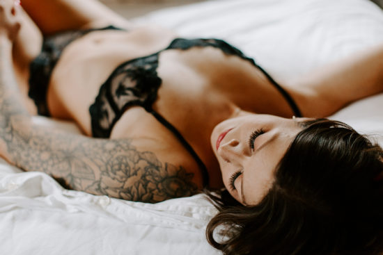 Woman posing on bed in lingerie to show the power of boudoir