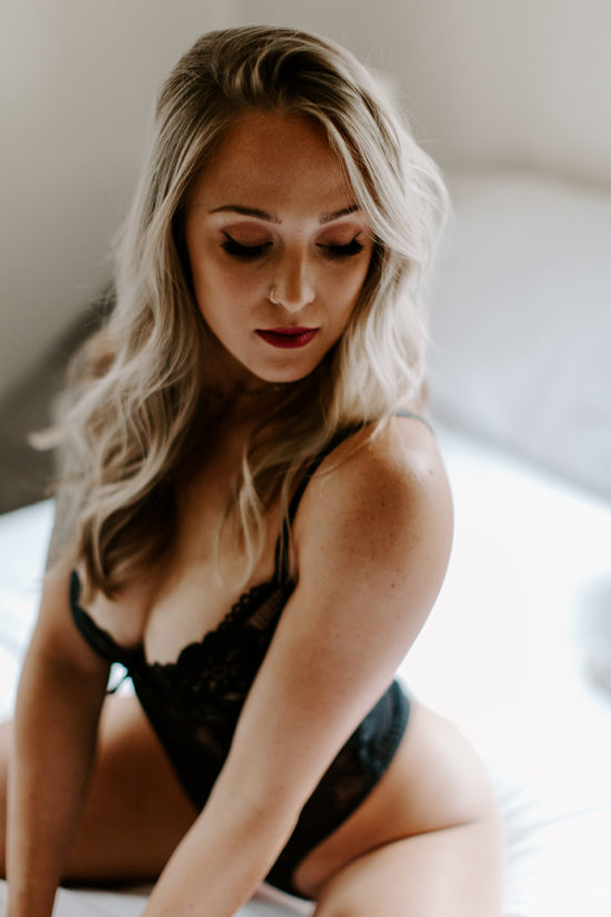 Woman posing on bed in lingerie to show the power of boudoir