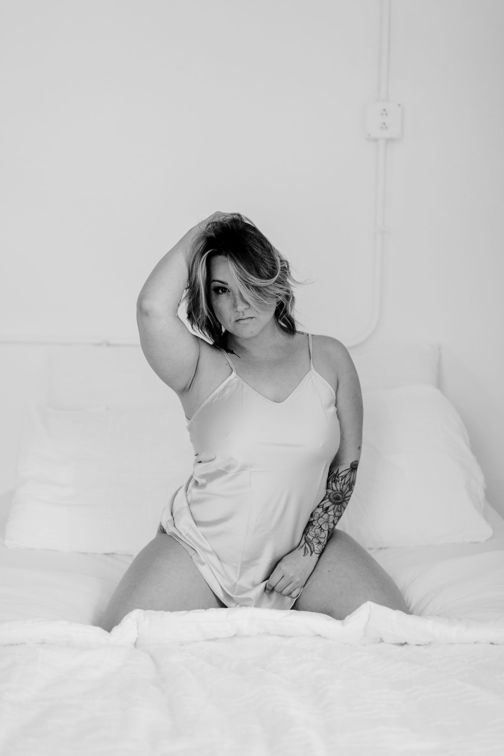 Boudoir session of a woman on a bed posing seductively