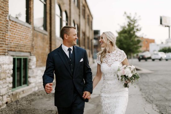 Carl and Megan walk hand in hand after their Crossroads wedding