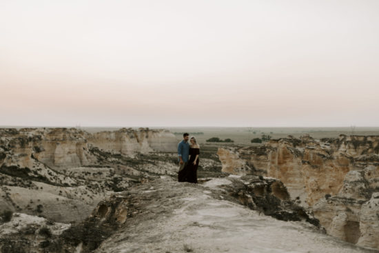 Couple stands overlooking Little Jerusalem rock formation for their engagement photos