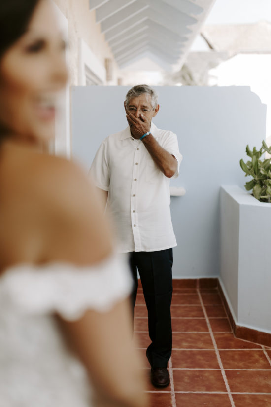 Father looks at his daughter, a bride, during their first look at the bride's destination wedding in Mexico