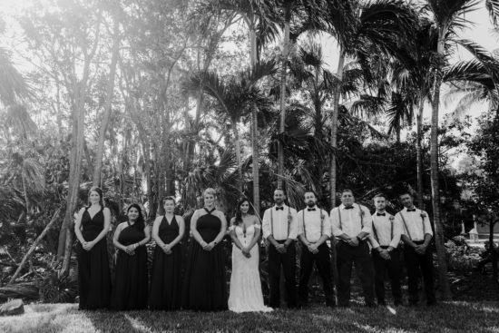 Wedding party stands in front of palm trees in Mexico during their destination wedding