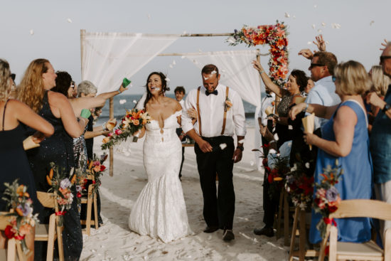 Bride and groom walk down the aisle and smile with joy during their destination wedding in Mexico