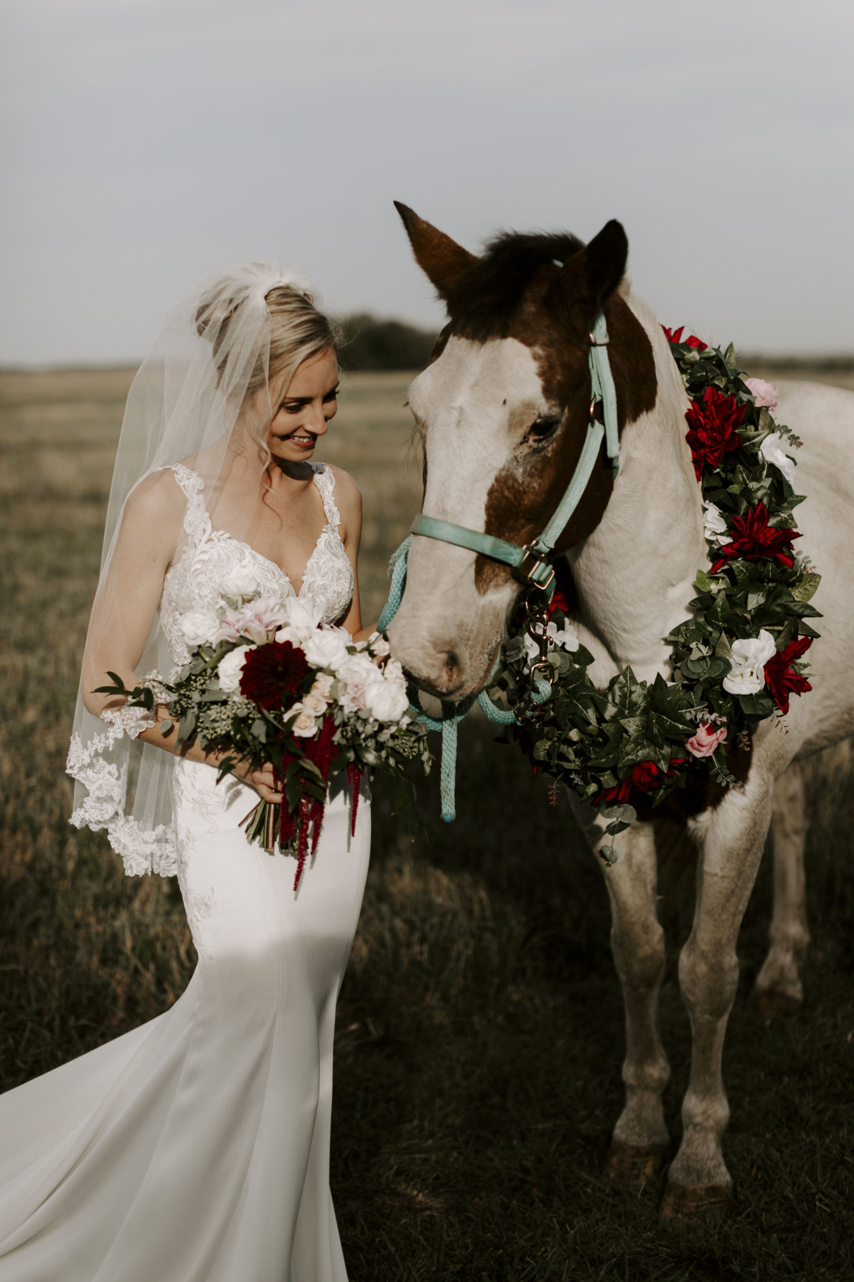 Bride poses with her horse at her Kansas farm wedding