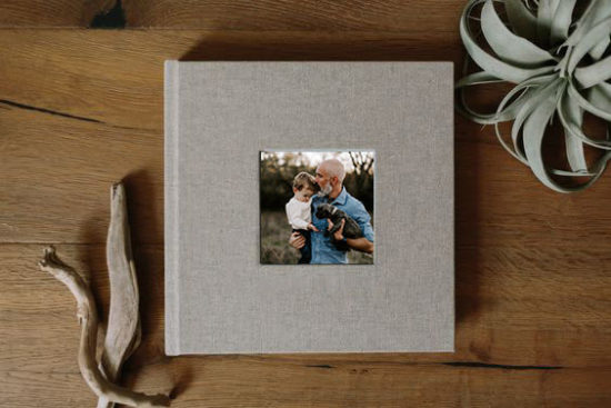 A photo album sitting on a table illustrates how to give photos as Christmas gifts