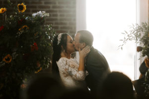 Groom and bride kiss at the end of their wedding