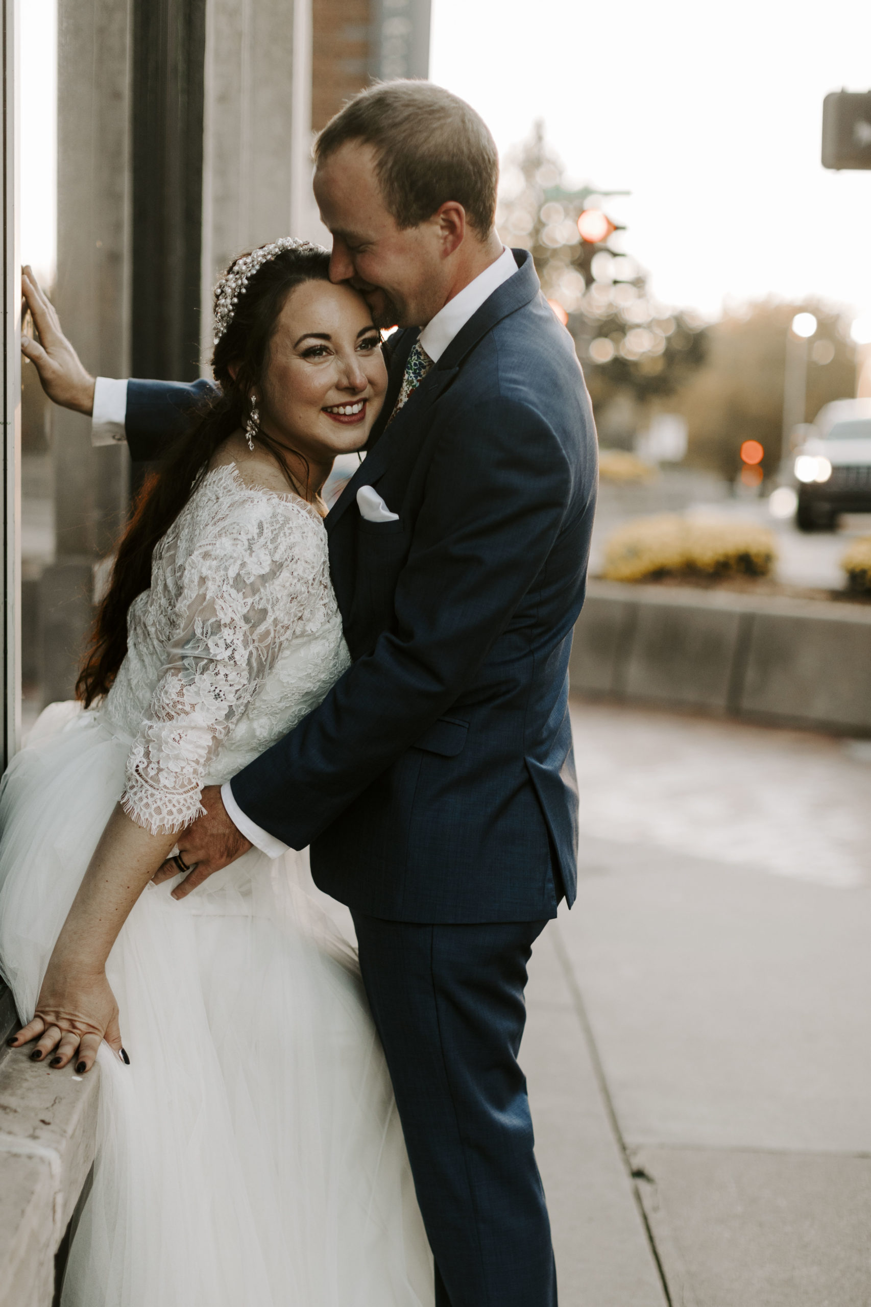 Groom kisses his bride in downtown Lawrence, KS