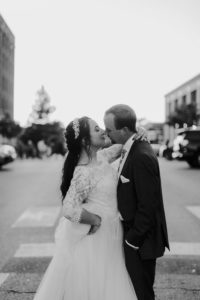 Bride and groom kiss on Massachusetts Street in downtown Lawrence KS