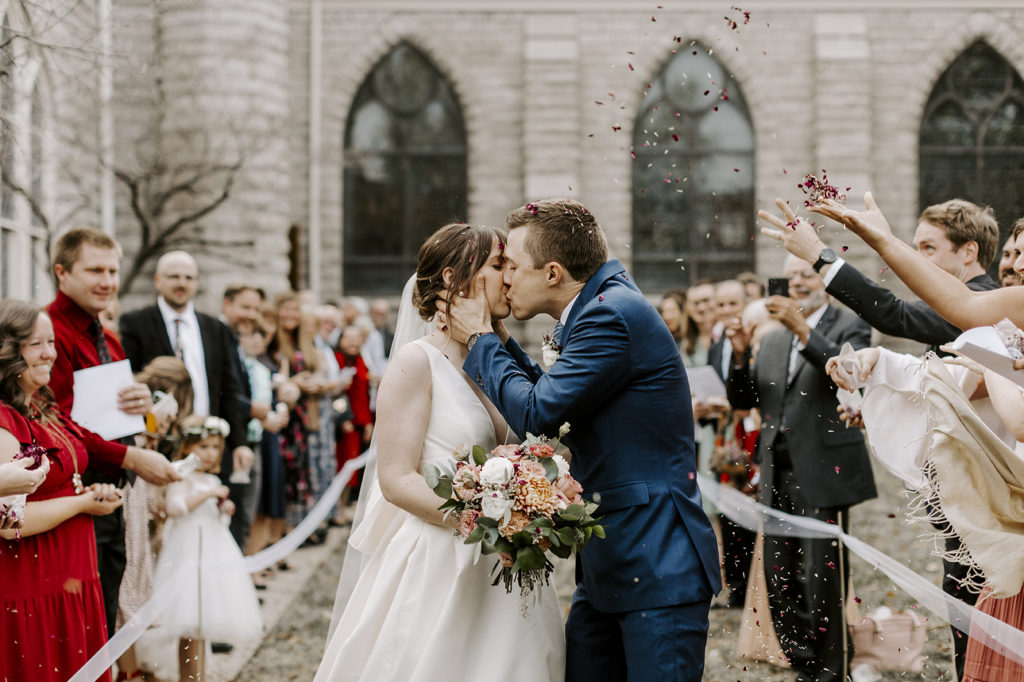 The bride and groom kiss outside of St. Paul's Episcopal Church after their upscale Kansas City wedding.