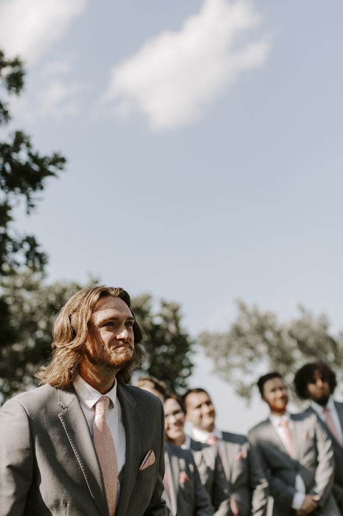 The groom tears up as he watches his soon-to-be-wife walk down the aisle before their Kansas lake house wedding.