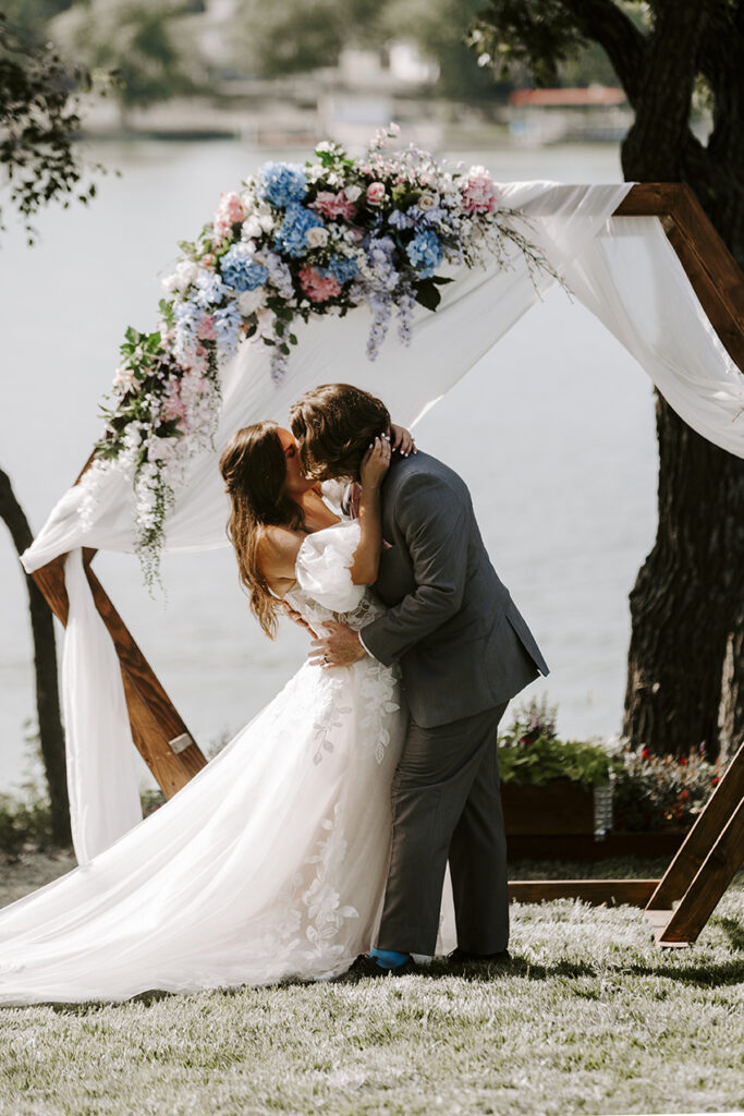 The bride and groom kiss during their Kansas lake house wedding.