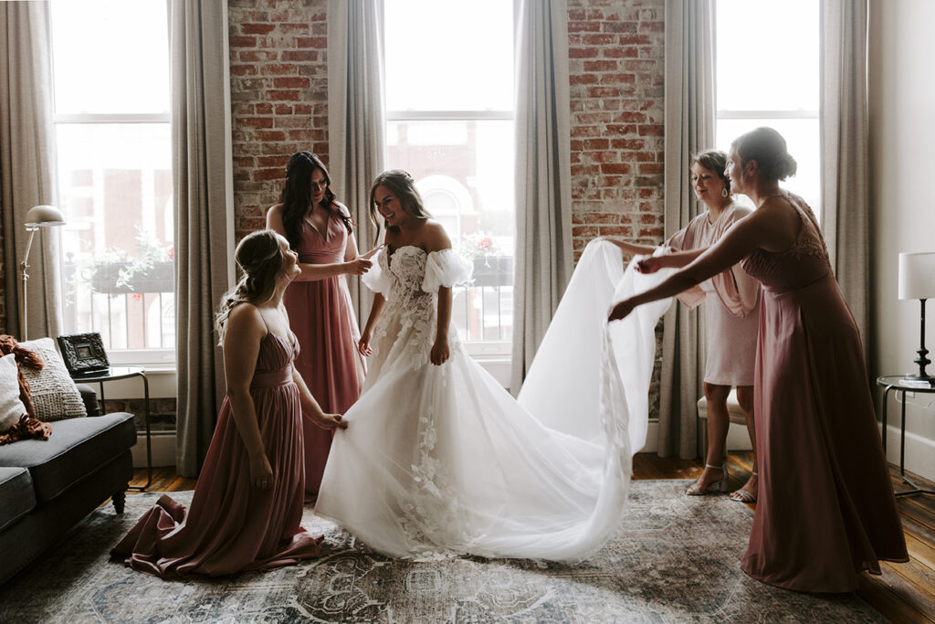Katie's mother and her bridesmaids fawn over her before her Kansas lake house wedding.