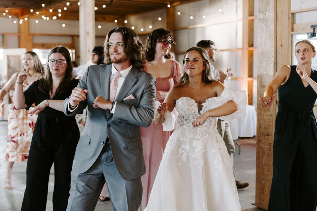 The bride and groom lead a dance during the reception of their Kansas lake house wedding.