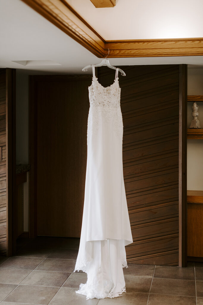 Mia's wedding dress hangs in the corner of the Chapel Study before her Powell Gardens wedding.
