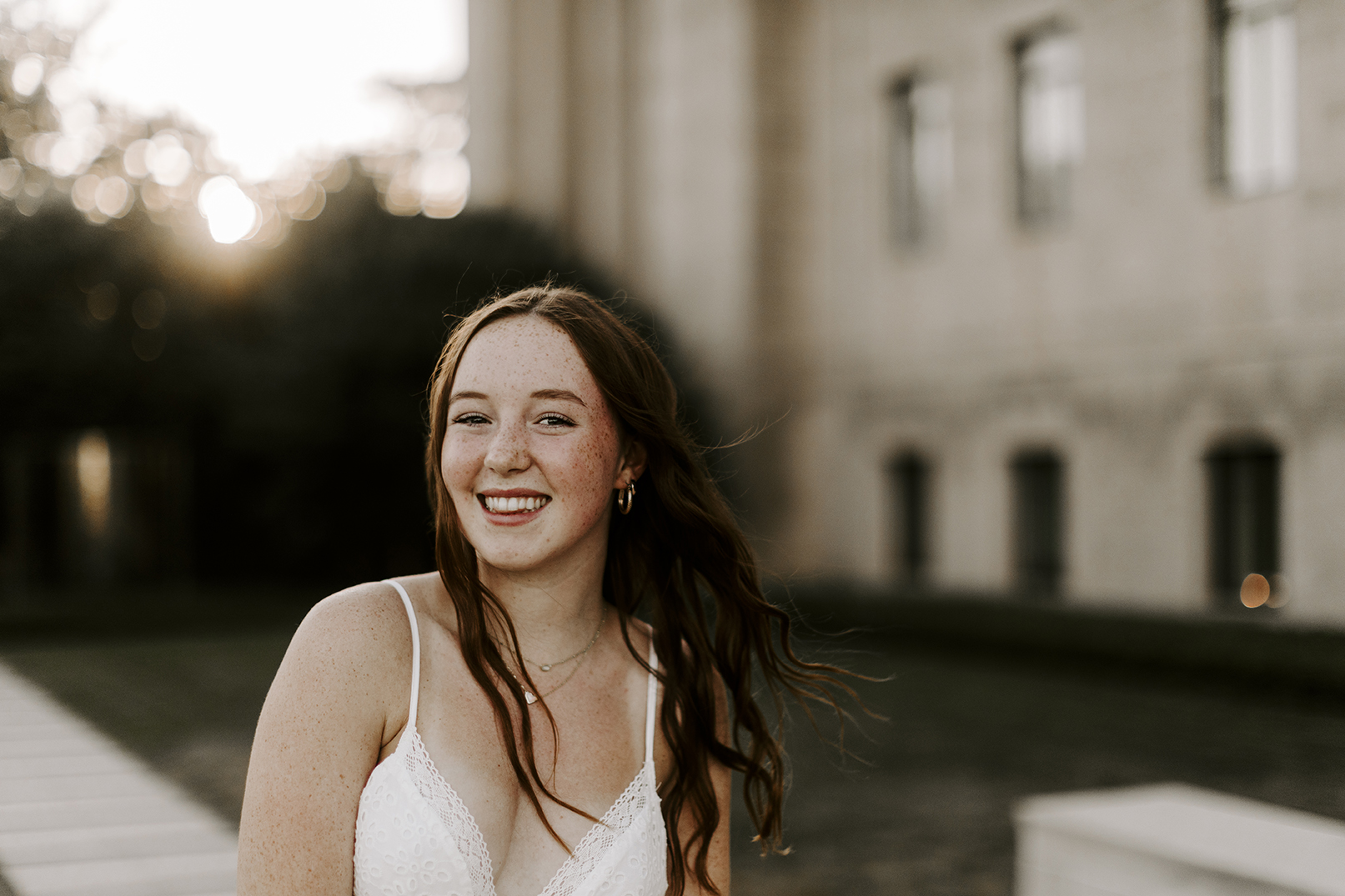 Adelaide poses smiling at the camera for her senior session in Kansas City.