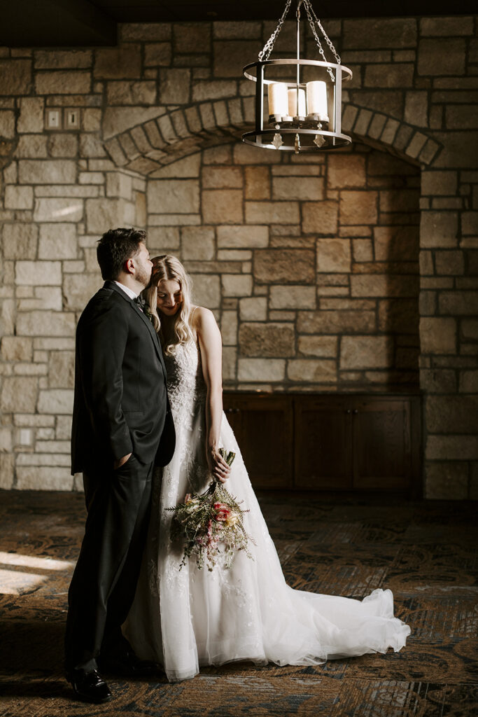 The bride and groom snuggle up together at their Oread wedding in Lawrence KS