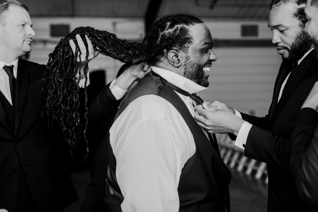The groom gets help from his groomsmen as he preps for his North Lawrence wedding