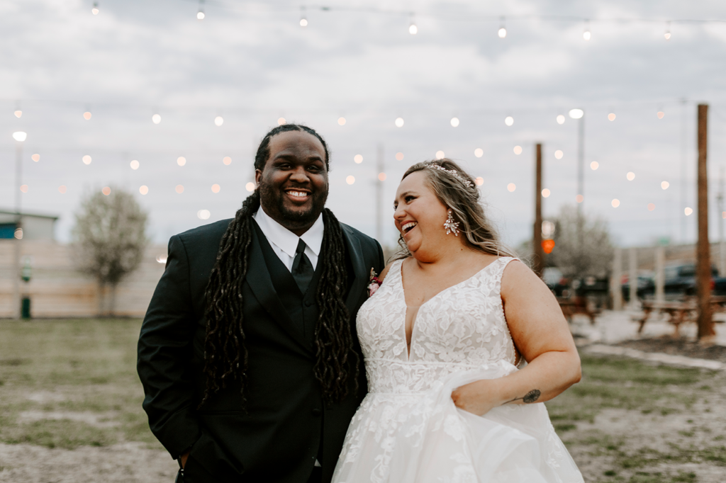 The bride and groom pose together, smiling after their North Lawrence wedding.