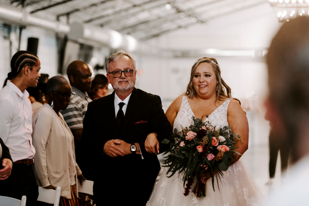 The bride walks down the aisle with her father ahead of her North Lawrence wedding.